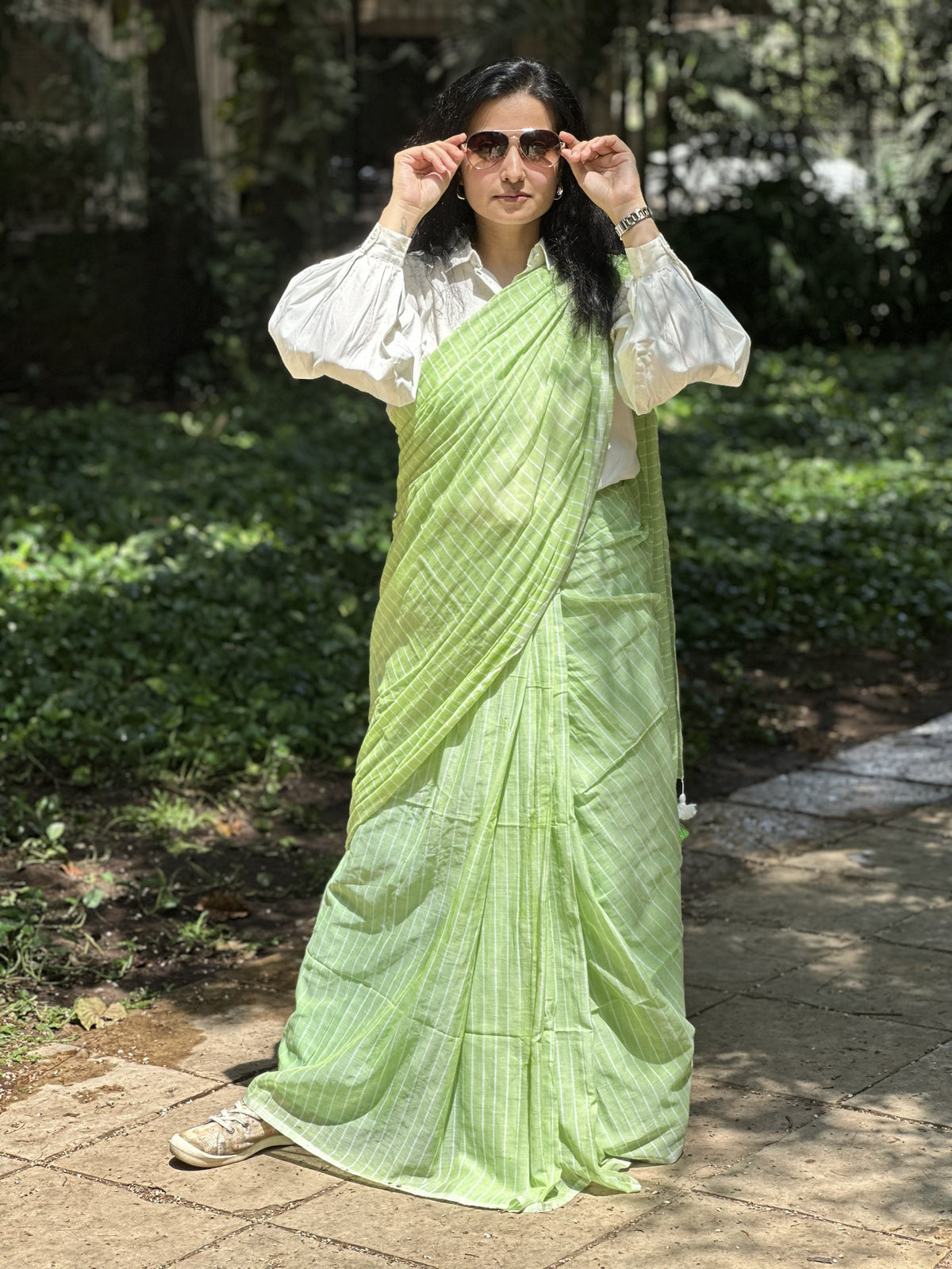 Light green mul cotton saree with subtle white stripes.