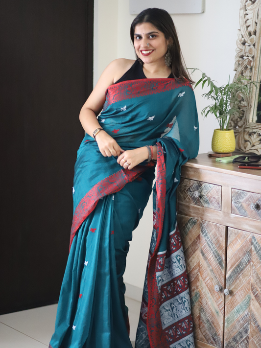 Green handwoven Assamese khadi cotton saree with contrast pink border.