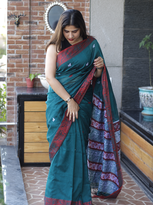 Green handwoven Assamese khadi cotton saree with contrast pink border.