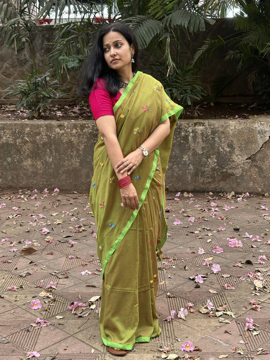 Olive green dual-tone mul cotton saree with floral embroidery.