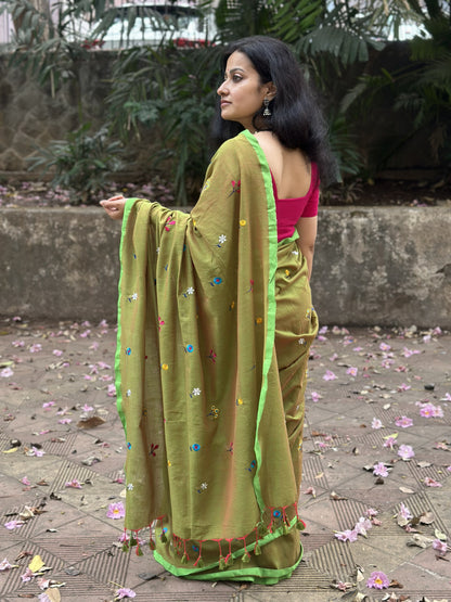 Olive green dual-tone mul cotton saree with floral embroidery.