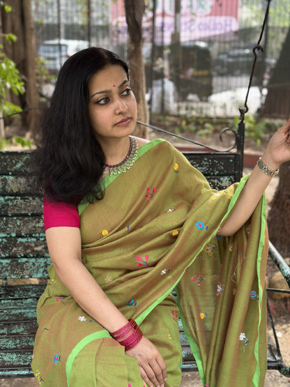 Olive green dual-tone mul cotton saree with floral embroidery.