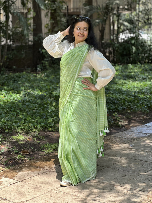 Light green mul cotton saree with subtle white stripes.
