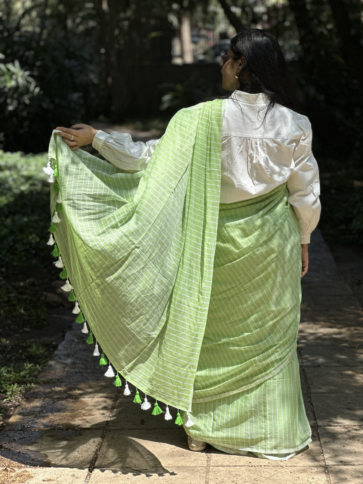 Light green mul cotton saree with subtle white stripes.