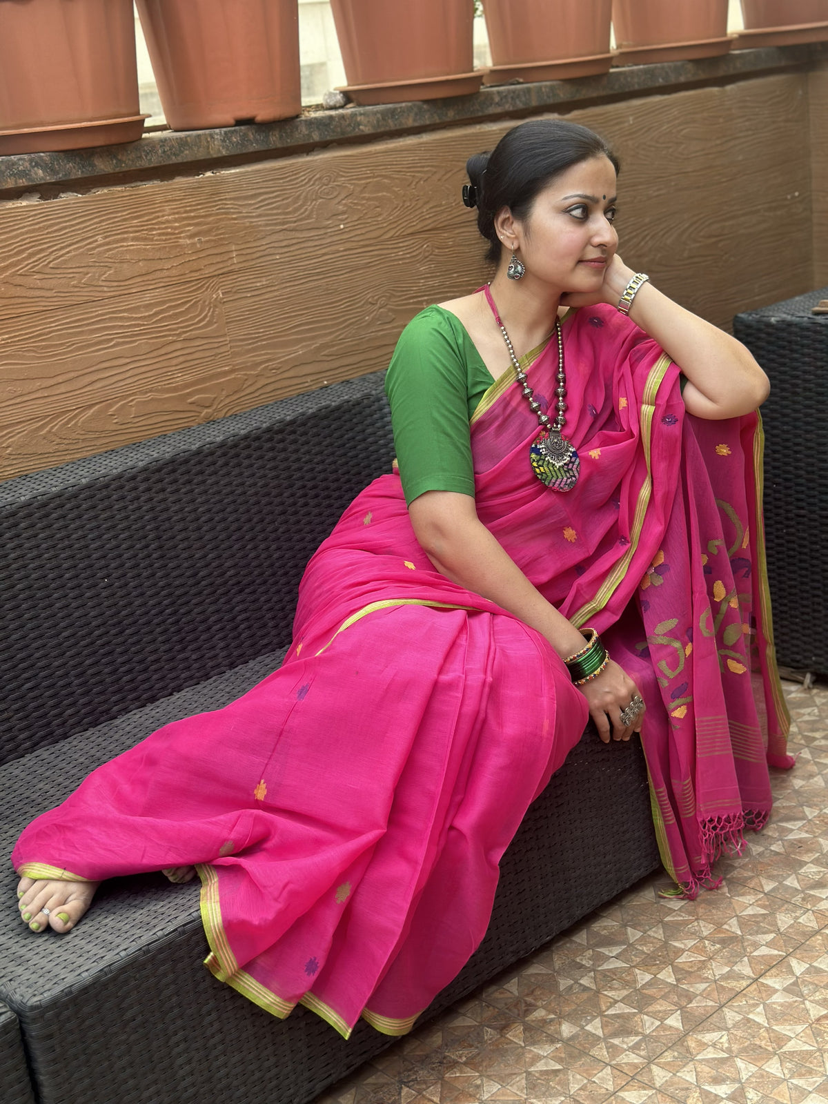 Pink handloom cotton Jamdani saree with multicolour buttis and green border.