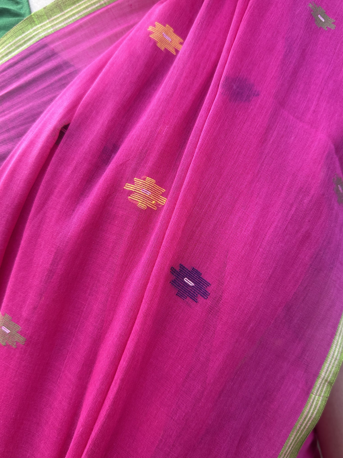 Pink handloom cotton Jamdani saree with multicolour buttis and green border.