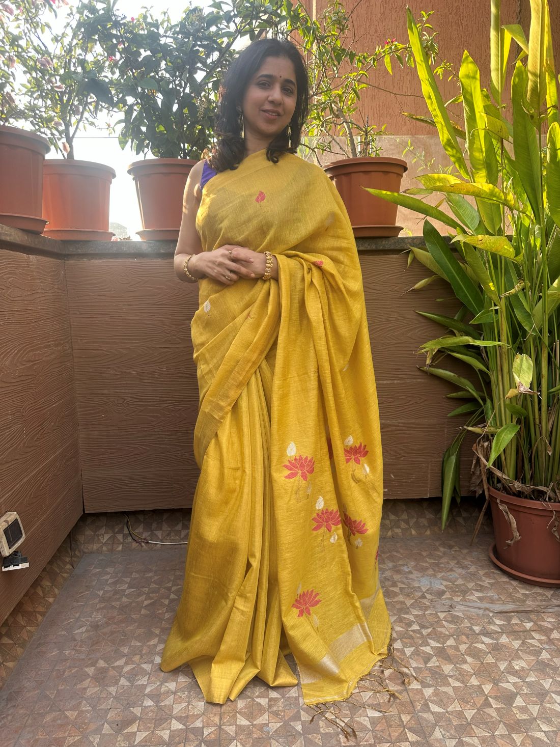 Yellow tissue linen handloom saree with elegant lotus and leaf motifs.