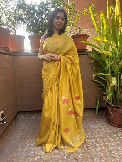 Yellow tissue linen handloom saree with elegant lotus and leaf motifs.
