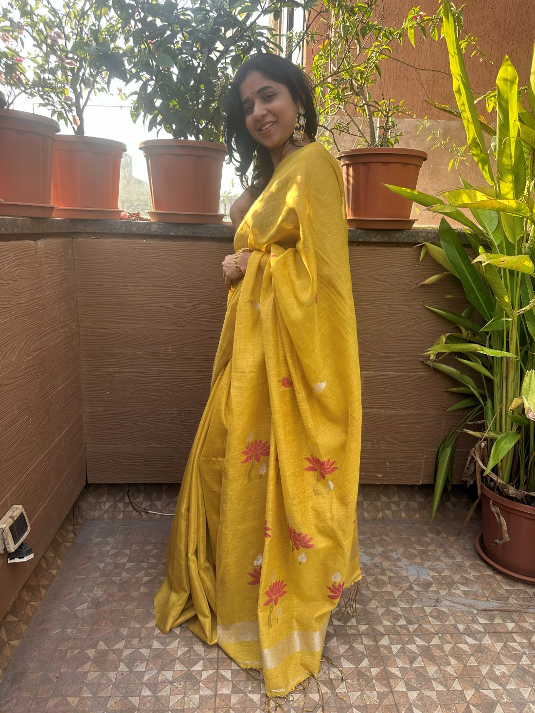 Yellow tissue linen handloom saree with elegant lotus and leaf motifs.