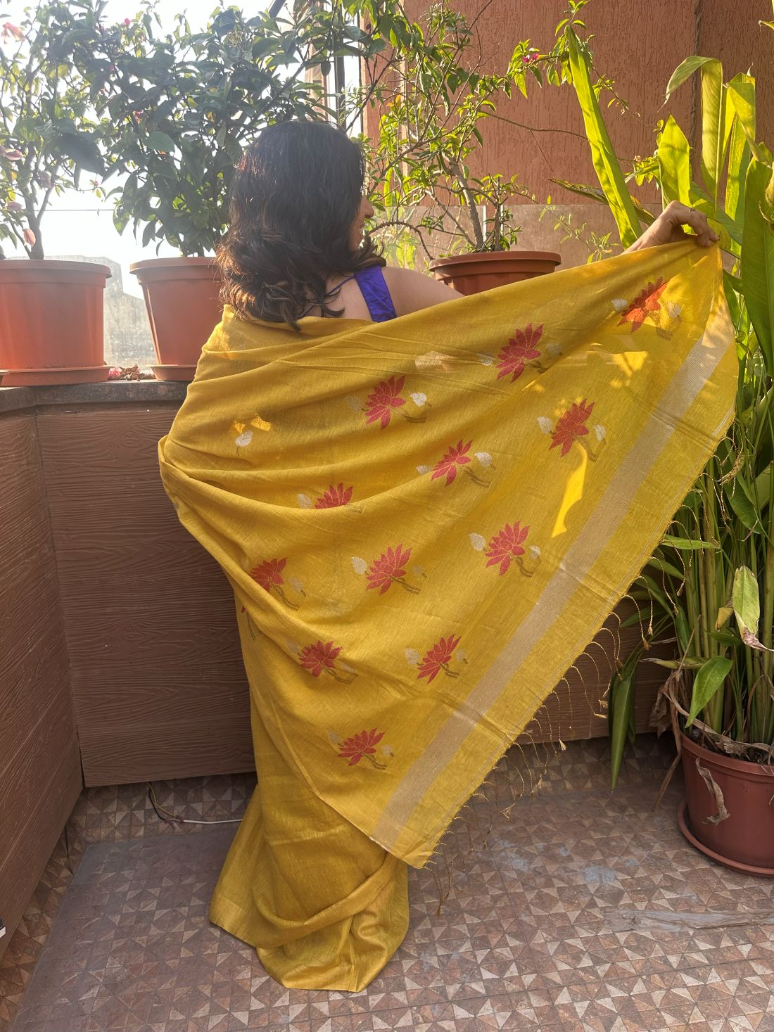Yellow tissue linen handloom saree with elegant lotus and leaf motifs.
