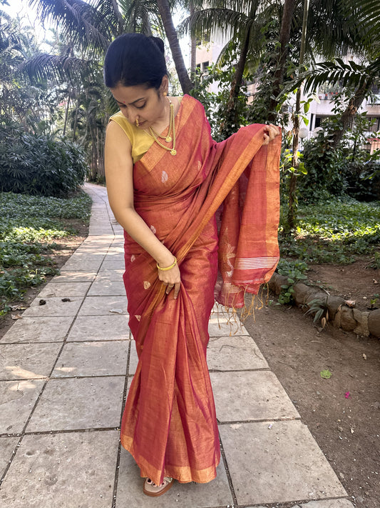 Red tissue linen handloom saree with elegant lotus and leaf motifs.