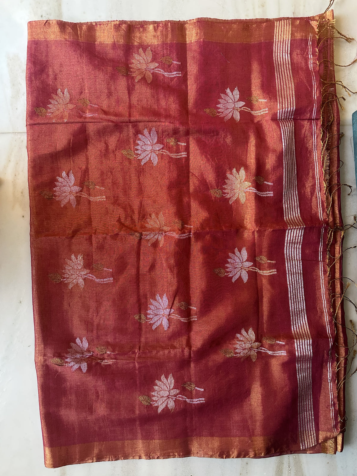 Red tissue linen handloom saree with elegant lotus and leaf motifs.