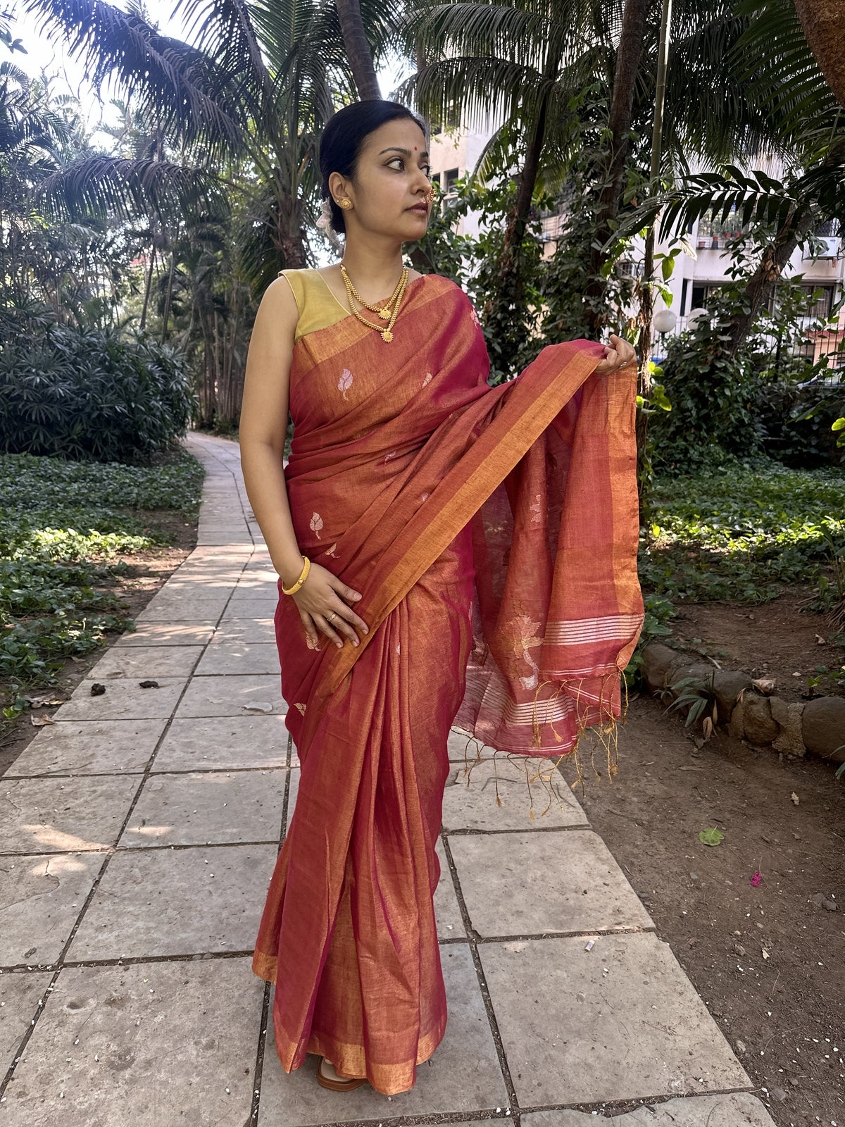 Red tissue linen handloom saree with elegant lotus and leaf motifs.